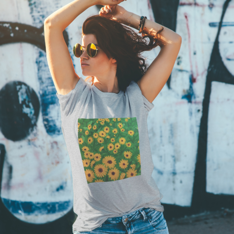 Woman wearing grey tshirt with decal of green grass and yellow flowers