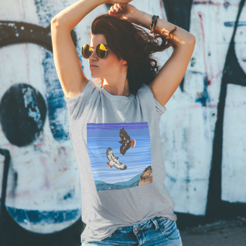 Woman wearing grey tshirt with decal of two eagles against a blue sky