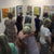 Crowd of people looking at paintings at a gallery opening