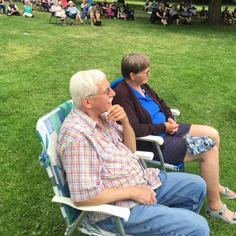 Couple sitting in lawnchairs listening to outdoor concert