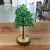 Green glass tree on round wooden base