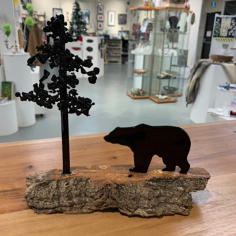 Black glass grizzly facing black glass tree, mounted on brown driftwood