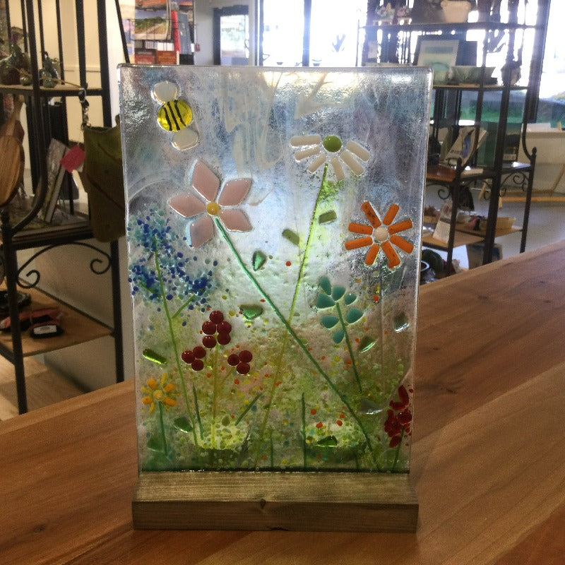 Glass candle shield decorated with daisies, flowers, and a bee