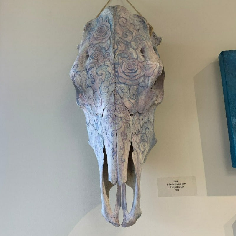 Cow skull decorated with carved and tinted flowers and vines