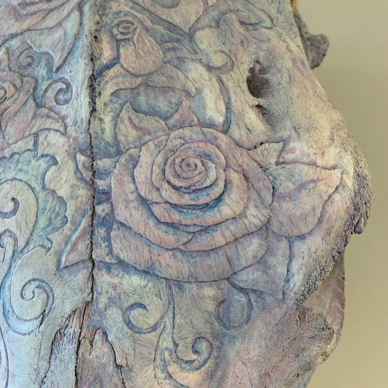 Detail of cow skull decorated with carved and tinted flowers and vines